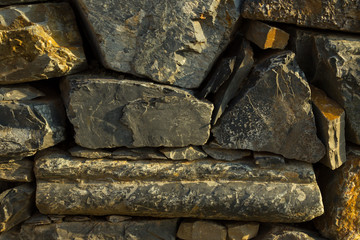 Artistic texture of a rustic vintage brownish stone wall to be used as background