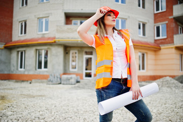 Engineer builder woman in uniform waistcoat and orange protective helmet hold business paper...