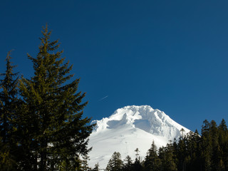 Snowy mountain with jet high above
