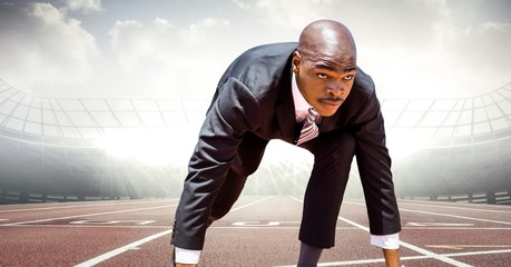 Business man at start line on track against flares