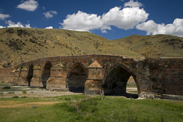 Fototapeta na wymiar Historical Cobandere Bridge built in 1298 on Aras River, Kars Turkey.