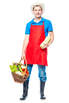 Vertical Portrait Of A Farmer In Full Length With A Crop Of Vegetables On A White Background