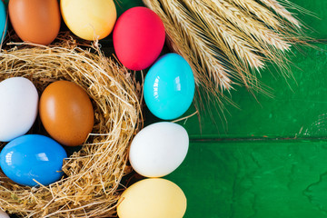 Bright colored dyed eggs on wooden table. Happy Easter eggs card