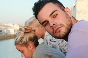 Fototapeta premium Handsome guy looking at the camera and in the background a boy and a girl