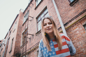 A hipster girl in an old courtyard posing and smiling