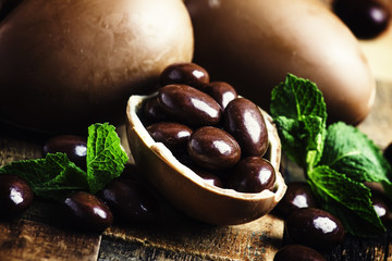 Easter composition with chocolate eggs, vintage wooden background, rustic style, selective focus