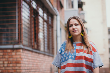 A hipster girl in an old courtyard posing and smiling