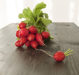 Bunch of fresh red radishes on a wooden table