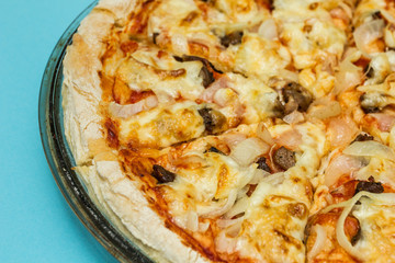Homemade pizza on a blue background.