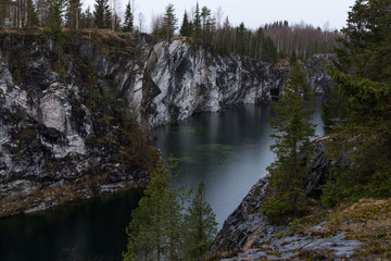 Deep dark lake and the marble canyon during early spring in Russia
