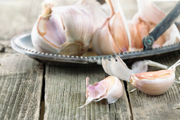 Garlic on an ancient metal dish on a wooden table