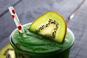 Healthy green smoothie from spinach and kiwi on a wooden table, selective focus