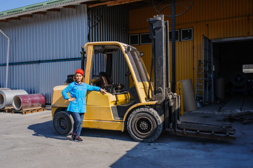 Fototapeta na wymiar Portrait of Female Lift Truck Driver In Factory