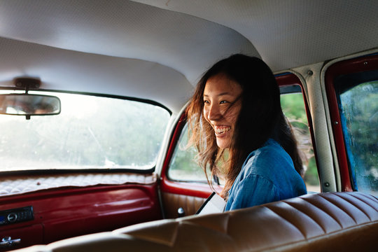 Happy woman laughing while sitting in the car