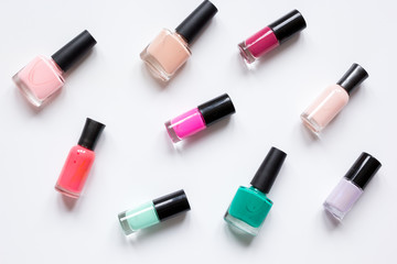 Obraz premium Butelki z lakierem do paznokci na białym tle wzór widok z góry