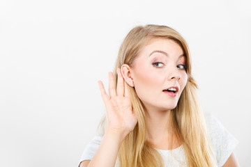 Woman putting hand ear to hear better