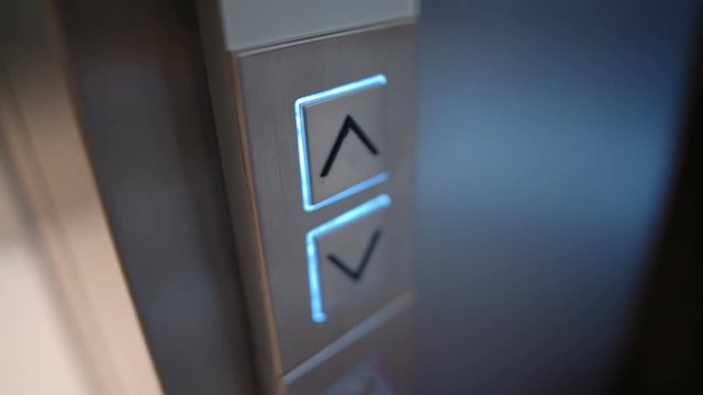 Young Woman Presses a Button of Lift to go Up by a Finger with a Painted Nail