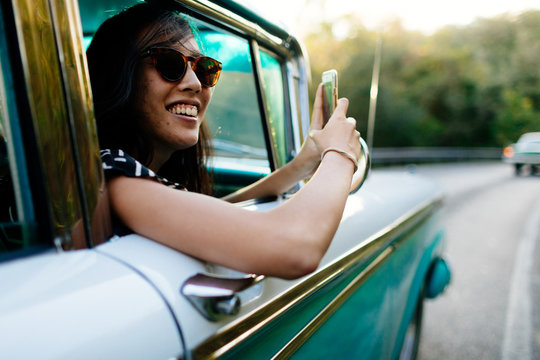 Twenty something laughs in 50's car ride in Vinales, Cuba