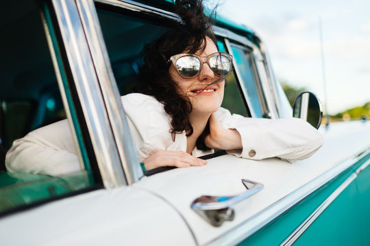 Twenty something laughs in 50's car ride in Vinales, Cuba