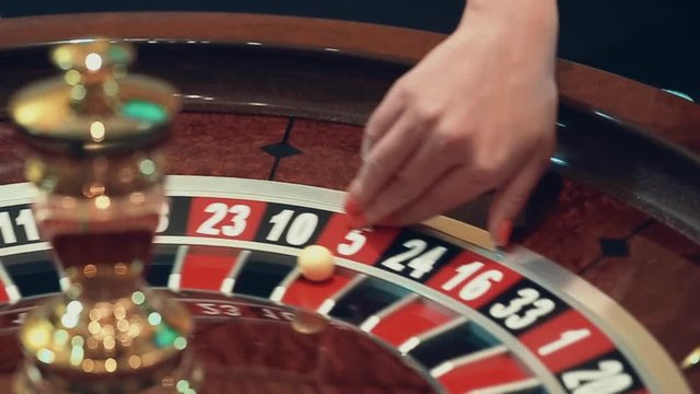 casino: roulette the girl spins the ball. slow motion.