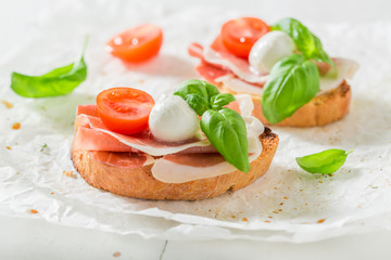 Crisp bruschetta with prosciutto, tomato and mozzarella for a snack