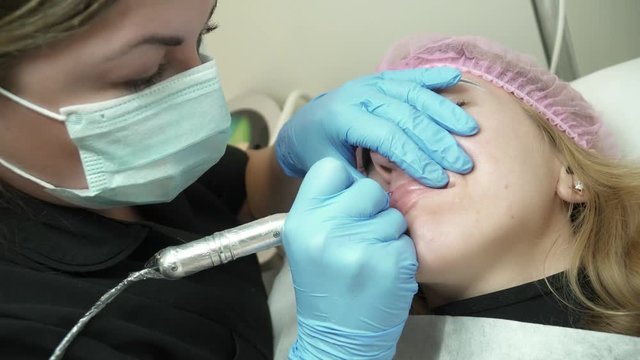 Cosmetologist is making the permanent makeup