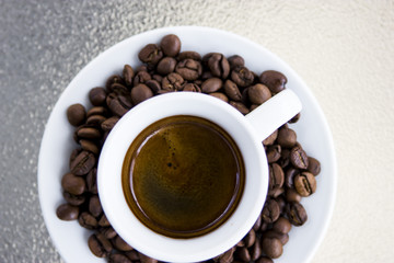 Espresso coffee. Coffee beans on a saucer and a small white cup