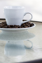 Espresso coffee. Coffee beans on a saucer and a small white cup