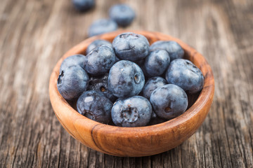 Deluxe blackberries in bowl on wooden background close up top view