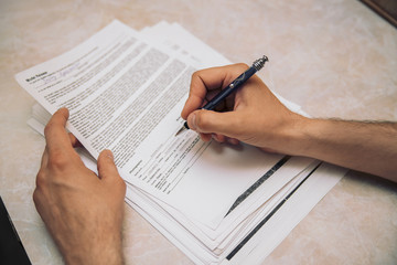 Man's hand is filling in document