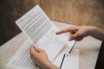 Obraz premium Finger of business man pointing to the paper report on the table