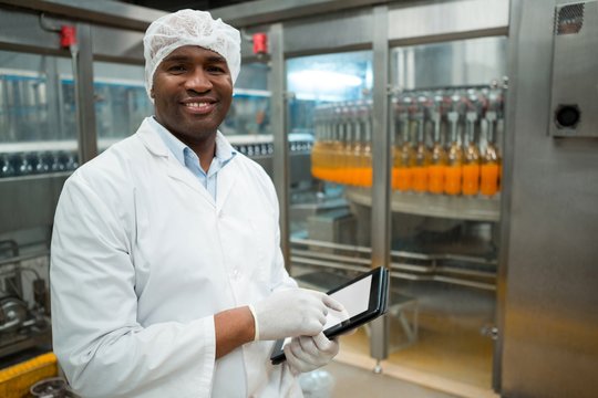 Portrait of male worker holding digital tablet in factory