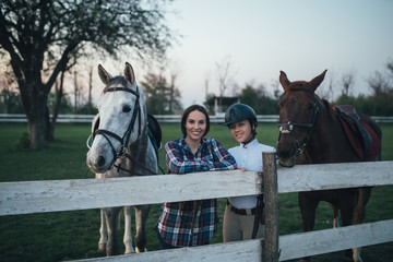 Beautiful young women enjoying at ranch with her two horses. 