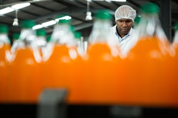 Male worker seen through juice bottles