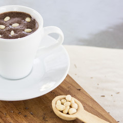 Hot chocolate with pine nuts. Sweet dessert drink in a cafe