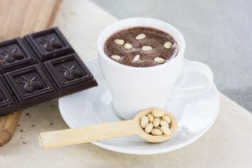 Hot chocolate with pine nuts. Sweet dessert drink in a cafe
