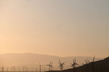 Windmill turnbines on a hill at sunrise