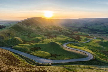 Zelfklevend Fotobehang Zonsondergang bij Mam Tor in het Peak District met lange kronkelende weg die door de vallei leidt. © _Danoz