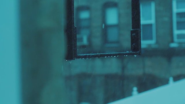 Slow motion of rain drops bouncing of off the fire escape ladders