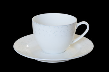 White porcelain cup with a saucer for tea or coffee, demitasse or teacup. Isolated, black background.