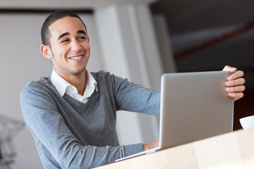 Smiling worker with laptop in office