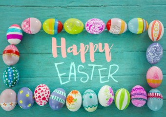 Blue and pink type surrounded by easter eggs on teal table