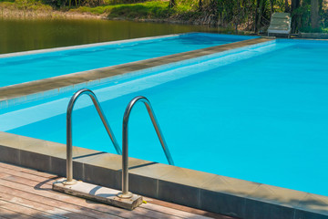 Swimming pool stair with wooden flooring in resort.