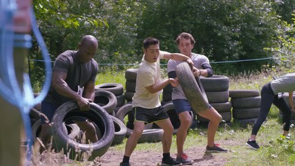 Competitors in endurance sports event running and stacking tires - Powered by Adobe