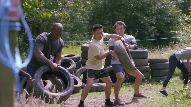 Competitors in endurance sports event running and stacking tires