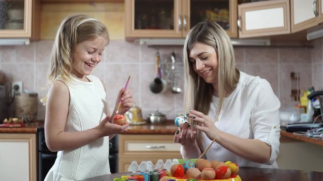 Mom and daughter are preparing for Easter. paint eggs