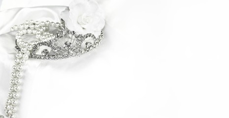 Bridal wedding decorations soft white bride background, silver crown and pearls on satin with space...