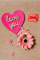 Fototapeta na wymiar Love You - wooden words on pink heart with corrugated paper background 