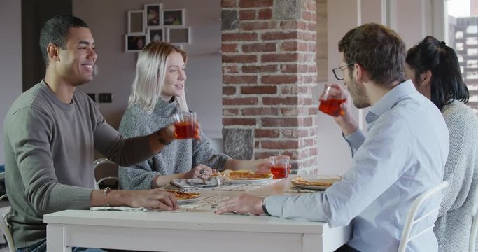 multiethnic group of friends people enjoy having lunch or dinner meal together eating pizza and toast indoor in modern industrial house. 4k handheld video shot