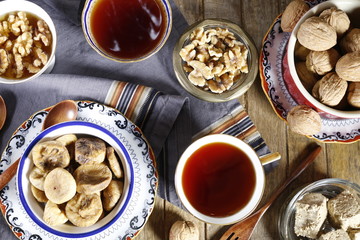 Cup of brewed tea with eastern sweets and spices on wooden table